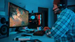 a man wearing headphones and sitting at a desk with a computer